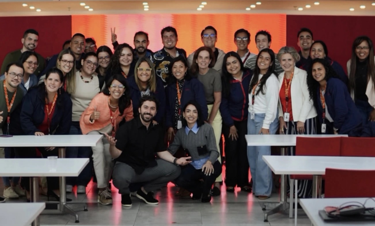 A group of smiling professionals posing together in a training room